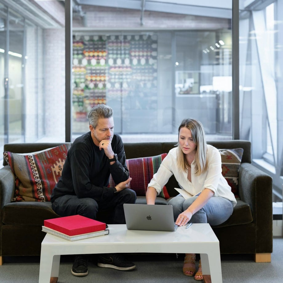Two people working on a laptop in an office